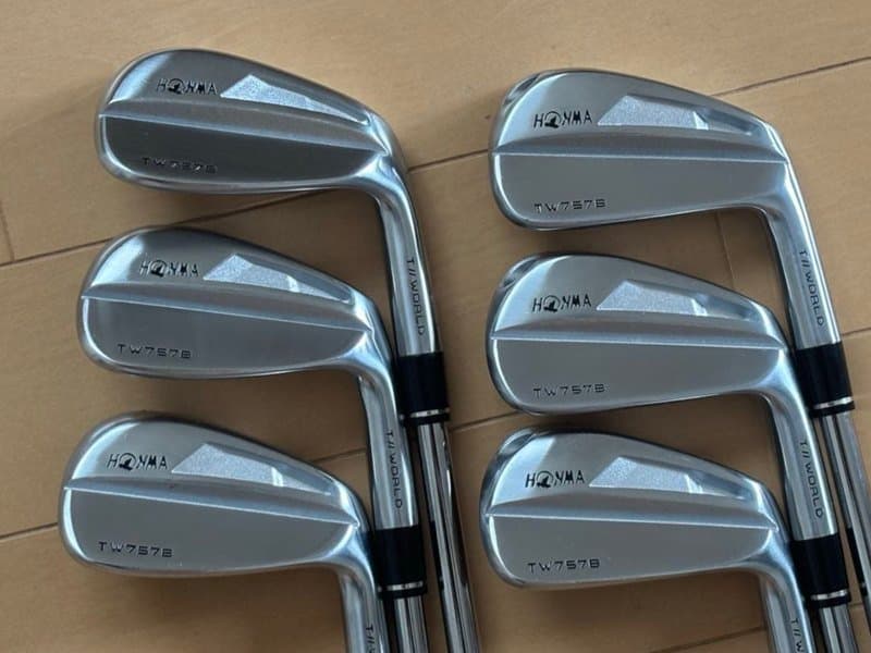 เหล็กชุด Honma TW757B หกชิ้นวางเรียงสองแถวบนพื้นไม้