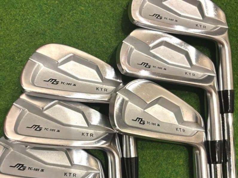หัวเหล็ก Miura TC-101s วางเรียงบนพื้นหญ้า เห็นโลโก้และสภาพหน้าไม้